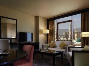 a living room with a couch and a large window at Zamzam Pullman Madina in Medina