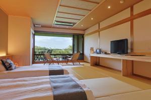 a room with a bed and a tv and a balcony at Kakimotoya in Sango