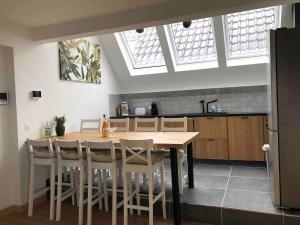 a kitchen with a wooden table and some windows at Spacious apartment in an authentic Mansion in Brussels