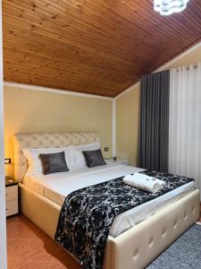 ein Schlafzimmer mit einem großen Bett und einer Holzdecke in der Unterkunft Hotel Fantazia in Shkodra + 53 Fotos