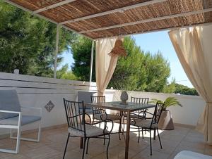 a patio with a table and chairs and a fence at B&B Pinulà in Maruggio