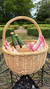 a basket of wine bottles and bread on a table at Kronovall Park Residence in Skåne-Tranås