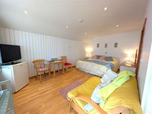 a hotel room with two beds and a television at Down Ende House Accommodation in Looe