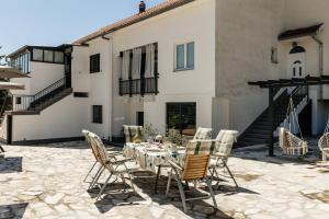 a patio with a table and chairs in front of a building at Studio Deluxe RoMa II in Imotski
