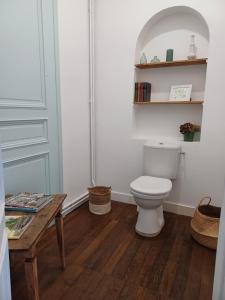a bathroom with a toilet and a wooden table at Chambre d'hôtes du Château de Digeon in Morvillers-Saint-Saturnin