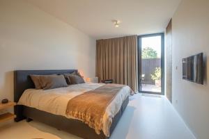 a bedroom with a large bed and a large window at NIEL71 Suite in Kerniel