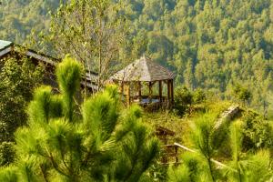 a wooden gazebo in the middle of a forest at Cloud Paradise Resort in Lao Cai