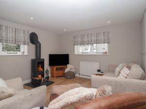 a living room with a couch and a fireplace at Wrens Nest in Kingsbridge