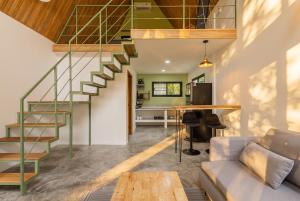 a staircase in a living room with a couch and a table at Coco Nest in Ko Phangan