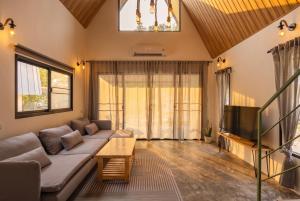 a living room with a couch and a tv at Coco Nest in Ko Phangan
