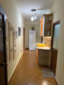 a kitchen with a white refrigerator and a tile floor at Apartment Sea View in Shëngjin