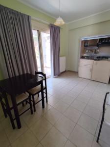a living room with a table and a kitchen at Hotel Theasis in Paralía Sergoúlas