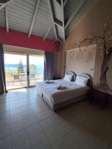 a bedroom with a bed and a view of the ocean at Hotel Theasis in Paralía Sergoúlas +27 photos