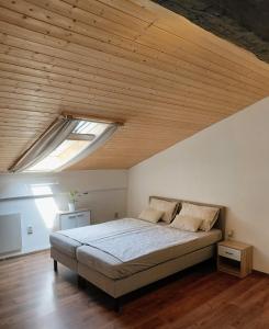 a bedroom with a large bed with a wooden ceiling at Ubytovanie Čadca 2026 in Čadca