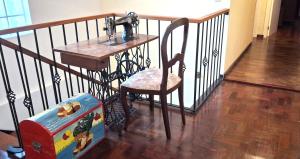 a table with a sewing machine and a chair on a staircase at A Casa de Santana in Santana +5 photos
