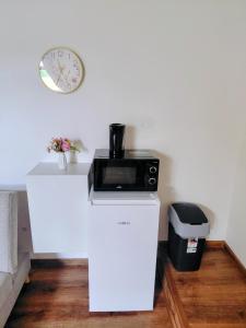 a microwave on top of a white counter with a clock at Ubytovanie Čadca 2026 in Čadca