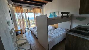 a small bedroom with a bunk bed and a sink at Sithonia Mare Hotel in Gerakini