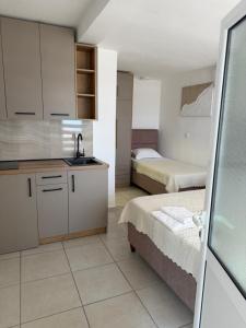 a kitchen with two beds and a sink in a room at Apartments Boss in Budva +68 photos