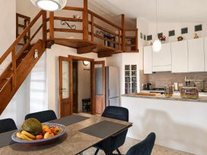 a kitchen and dining room with a table with a bowl of fruit at ALLOGGIO CASA IN PIETRA in Santu Lussurgiu