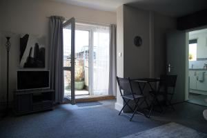 a living room with a table and a sliding glass door at Seaford Snug in Seaford