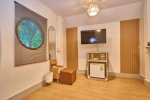 a living room with a tv and a chair in a room at Baan Suan ChiChan บ้านสวนชีจรรย์ in Na Jomtien +63 photos
