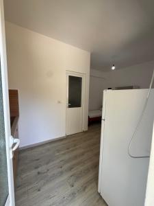 an empty room with a white refrigerator and a door at City & Sea Hideout in Himare +3 photos