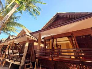 a building with chairs and a palm tree at Phi Phi Maiyada Resort in Phi Phi Islands