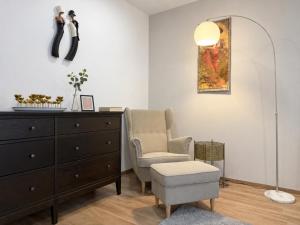 a living room with a dresser and a chair and a mirror at Veleslaveenka - Spacious Apartment in Pilsen Old Town in Pilsen +12 photos