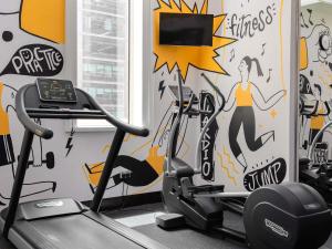a gym with a wall mural of a woman on a treadmill at ibis Dubai One Central in Dubai