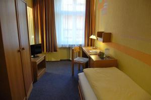 um quarto de hotel com uma cama e uma secretária em Hotel Graf Pückler em Berlim