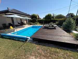 a backyard with a wooden deck and a swimming pool at MARINA HOUSE pool & garden in Beograd