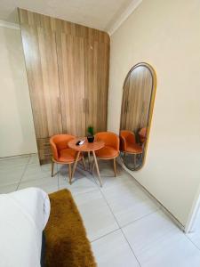 a room with a table and chairs and a mirror at Parklane Bed and breakfast in Gaborone