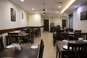 a restaurant with wooden tables and chairs in a room at Hotel S-mart In Delhi Airport & Free Airport Pickup in New Delhi