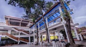 a building with tables and chairs in front of it at Apple Tree Resort & Hotel in Opol