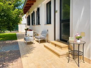 a patio with two chairs and a glass table at Serenity Garden in Stupinigi