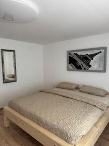 a bed in a bedroom with a white wall at Loft Fischbach bei Kallmünz 2 Schlafzimmer in Kallmünz
