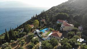 an aerial view of a house on a hill next to the water at Hotel Theasis in Paralía Sergoúlas
