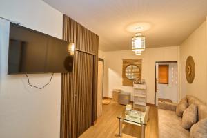 a living room with a flat screen tv on a wall at Baan Suan ChiChan บ้านสวนชีจรรย์ in Na Jomtien