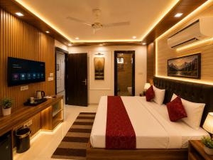 a bedroom with a bed and a flat screen tv at Hotel Aura Bellamonts Near Delhi Airport- Free Airport PickUp & Drop , Breakfast & Dinner Complementary in New Delhi +18 photos
