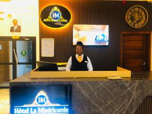 a woman sitting at a desk with a laptop at Hôtel La Miséricorde in Douala