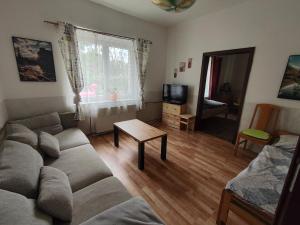 a living room with a couch and a table at Apartmány u koní in Děkov