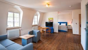 a living room with a couch and a bed and a table at Romantik Hotel Meisenheimer Hof in Meisenheim