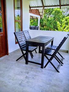 a wooden table and two chairs on a patio at Ranweli Resort Anuradhapura in Anuradhapura