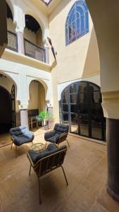 a patio with chairs and tables in a building at Riad Carllian in Marrakesh