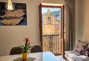 a living room with a table and a view of a church at ALLOGGIO CASA IN PIETRA in Santu Lussurgiu