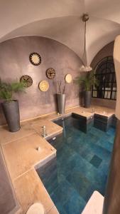 a large room with blue floors and potted plants at Riad Carllian in Marrakesh