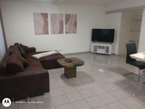 a living room with a brown couch and a tv at Ferienwohnung Fuchsbau in Werne an der Lippe