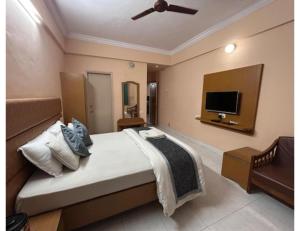 a bedroom with a bed and a flat screen tv at Hotel shree darshan Dwarka in Dwarka