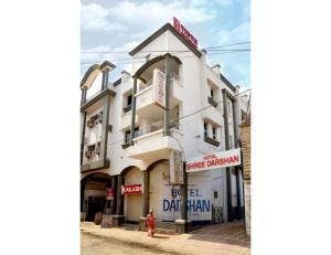 a white building with a sign on the side of it at Hotel shree darshan Dwarka in Dwarka