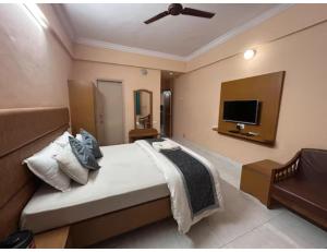 a bedroom with a bed and a flat screen tv at Hotel shree darshan Dwarka in Dwarka